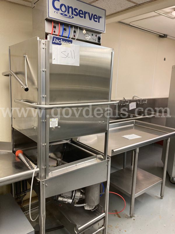 Jackson Conserver Industrial Dishwasher with stainless steel table and hot water booster